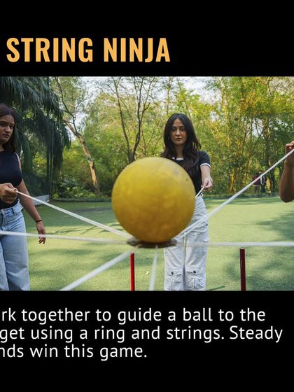 This is String Ninja, where steady hands win the game. Your team has to work together to guide a ball to its target using a ring and strings.
