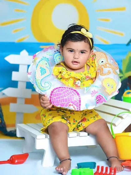 Ready for a swim with her floatie. Using creative props helps tell a story and brings our beach-themed studio session to life.