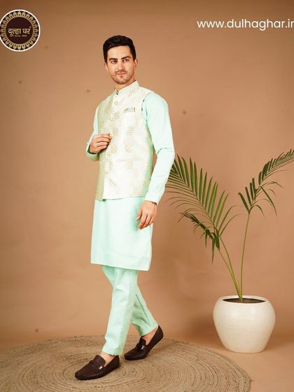 A fresh and elegant look with a pastel green kurta set and a light-colored brocade Nehru jacket.