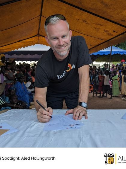 Aled Hollingworth signs a covenant at a buildOn project. Our alumni features showcase the diverse and meaningful paths our graduates take, providing inspiration for current students.