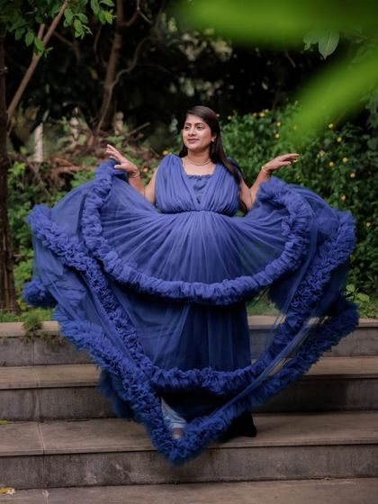 The lightweight tulle of this blue maternity gown allows you to play with the fabric, creating dynamic and joyful shots like this. It’s a fun and beautiful dress to wear for your photoshoot.