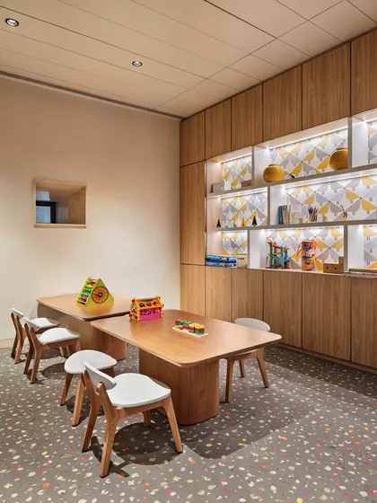 The kids' zone at the Elevate Clubhouse is designed to be a sanctuary for play and imagination. With its warm wood tones, colorful flooring, and accessible storage, the space is both functional and inspiring, providing a safe and engaging environment for children.