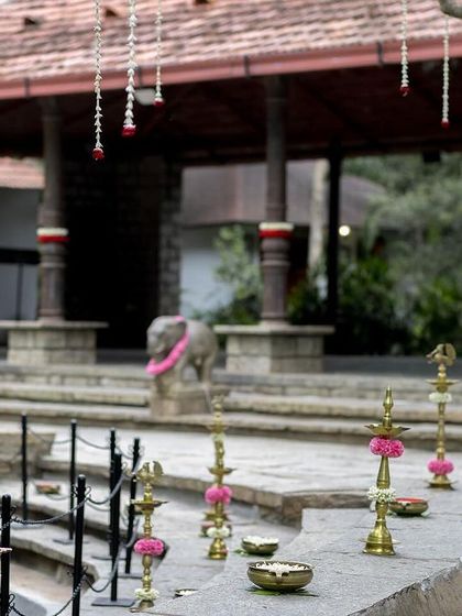 Brass lamps and pink flowers line the steps, creating a beautiful and traditional decorative element.