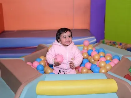 A happy toddler enjoying the ball pit. We have a dedicated area to ensure the smallest adventurers have a safe and fun space to themselves.