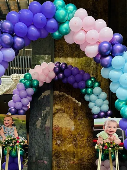 Personalization is key. We placed adorable photos of the birthday girl, Vani, on easels at the entrance, nestled within the balloon arches to welcome guests with a smile.