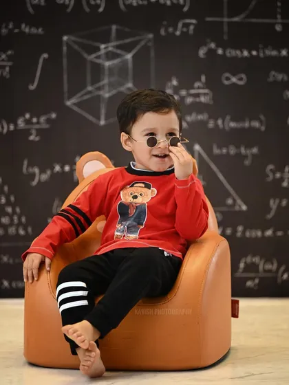 A playful and creative kids' portrait session in the studio, themed around a 'little genius' concept with a chalkboard and fun props.