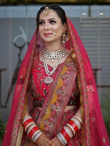 This shot captures the grandeur of the full bridal look, with the dupatta perfectly draped to frame her face and show off her jewelry.