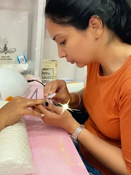 A student practices applying polish to a client's nails, focusing on precision and care.