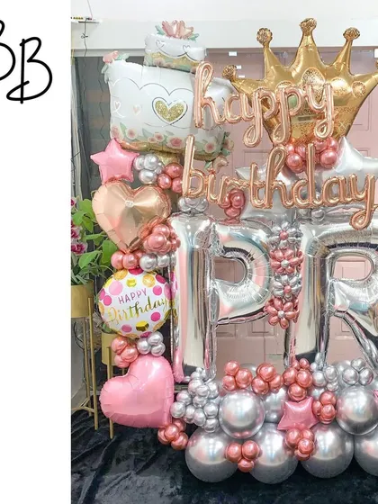 A glamorous initial display perfect for a chic birthday party. The large silver 'P' and 'R' balloons are surrounded by a sophisticated mix of pink, rose gold, and silver balloons, topped with a crown for a royal touch.