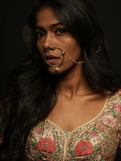 A close-up portrait focusing on the large traditional nose ring and the clean, flawless makeup on the model.