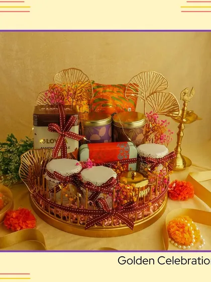 The 'Golden Celebration' hamper. This ornate metal tray is loaded with jars of treats and decorated with golden fans and a traditional diya, making it a grand centerpiece gift.