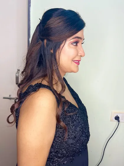 The side profile shows the soft, wavy hairstyle that complements the dramatic makeup.