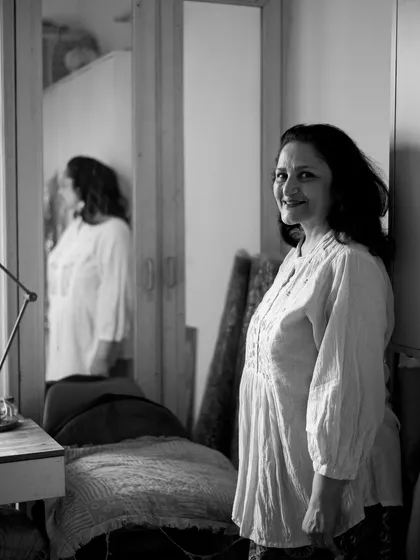 A woman standing by a mirror, her reflection captured alongside her. This black and white shot is a beautiful, quiet study of self.
