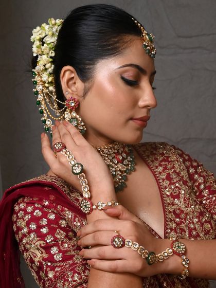 A side profile showcasing the hathphool (hand harness) and bangles that are part of this magnificent bridal set. Every piece is designed to coordinate perfectly.