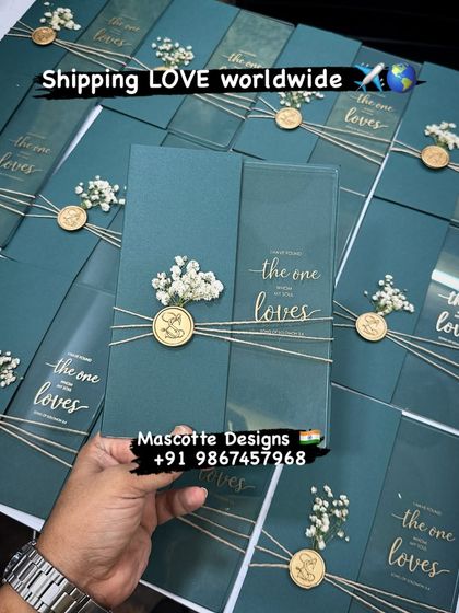 Shipping love worldwide. This image showcases a beautiful teal acrylic invitation, tied with twine and finished with a wax seal and dried flowers, ready to be sent to a happy couple.