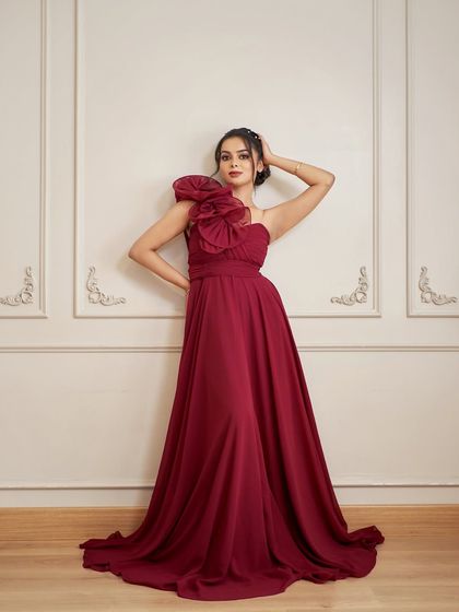 A full-length portrait of a model in the 'Nicolas' gown. The one-shoulder design and dramatic double-umbrella skirt create a powerful and elegant silhouette.