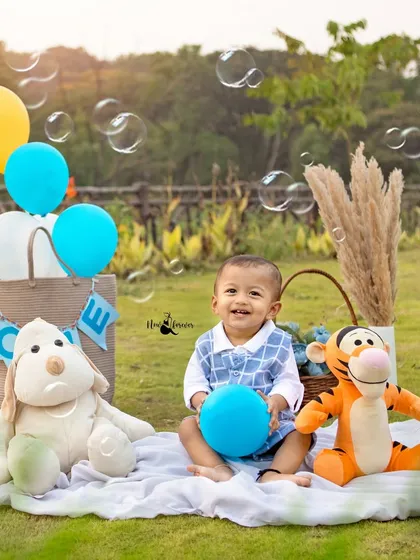 Surrounded by bubbles and his favorite toys, this little one is all smiles for his first birthday picnic. It's a perfect, relaxed way to capture this milestone.