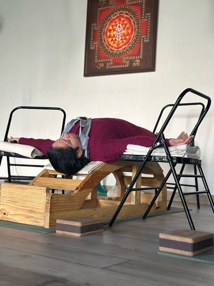 A calm mind is the ultimate weapon. This restorative backbend, performed on a specialized wooden bench and chairs, is designed to open the thoracic spine and calm the nervous system, preparing the mind for deep relaxation.