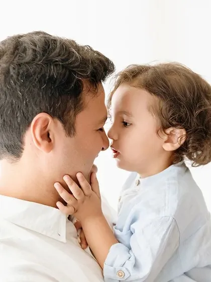 A touching father and son moment, nose to nose. This intimate pose creates a powerful and emotional portrait.