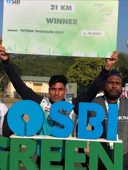 A 21km winner from my team proudly holding his prize cheque at the SBI Green Marathon. This is what victory looks like.