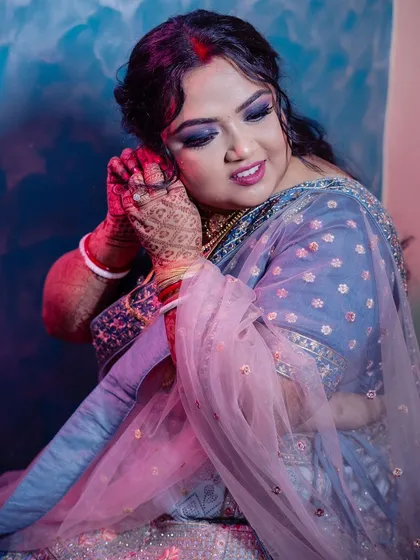 This is a beautiful reception look I created for my bride. We opted for a dramatic smokey eye and a soft pink lip, paired with a sophisticated updo to perfectly complement her blue and pink lehenga.