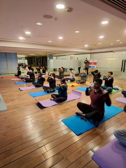 A corporate group practicing a breathing exercise to calm the mind and improve focus. Mindfulness is a powerful tool for workplace well-being.