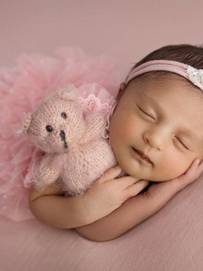 This angle perfectly captures the baby hugging her little teddy bear, an image of pure innocence and comfort.
