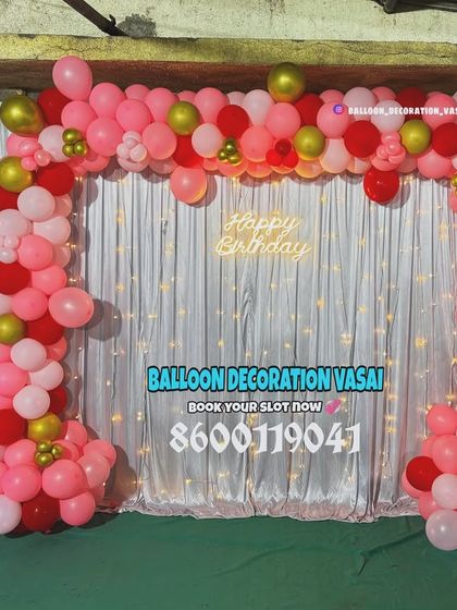 A lovely pink, red, and gold balloon arch for a first birthday. This setup is perfect for home parties, featuring a shimmer curtain, a neon sign, and a number '1' foil balloon.