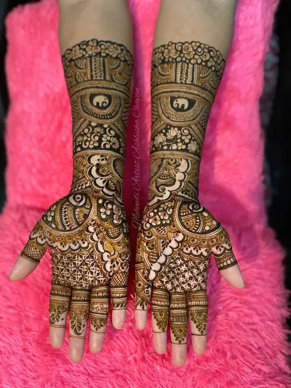 An intricate bridal design featuring elephants and peacocks. The use of negative space and detailed filling makes the motifs stand out beautifully.