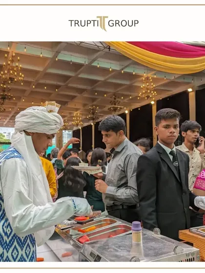 Our live counters are where the action is. Here, a chef in traditional attire serves guests from a bustling food station, showcasing the lively atmosphere of our events.