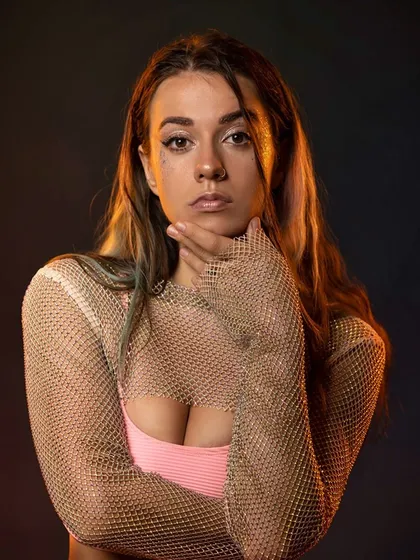 A dancer's portrait with warm lighting, focusing on her expression and the glamorous feel of the shot.