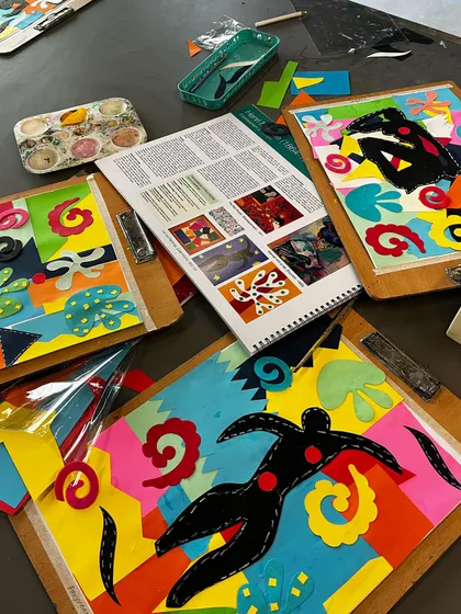 A table full of Matisse-inspired collages, showing the beautiful results of his "drawing with scissors" technique.