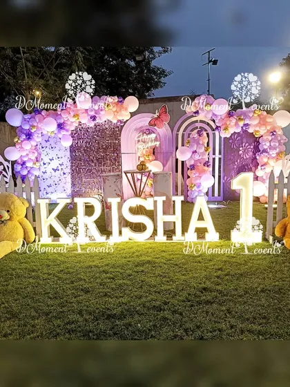 A wide shot of the beautiful butterfly-themed stage at night. The combination of marquee letters, teddy bears, and picket fences creates a charming and whimsical scene.