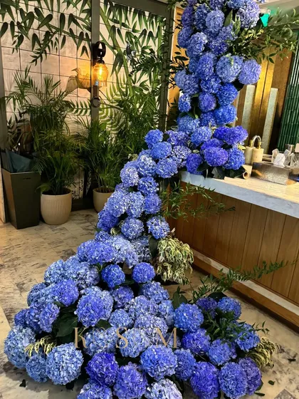 For this event, I designed a floral plunge pool using hundreds of blue hydrangeas. The goal was to create a breathtaking moment of drama and immersion, turning a simple corner into a sensational, cascading river of flowers.