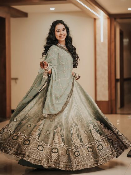 A full-length twirl shot of the bride in a beautiful, flowing lehenga. This captures her playful spirit and the gorgeous detail of her outfit.