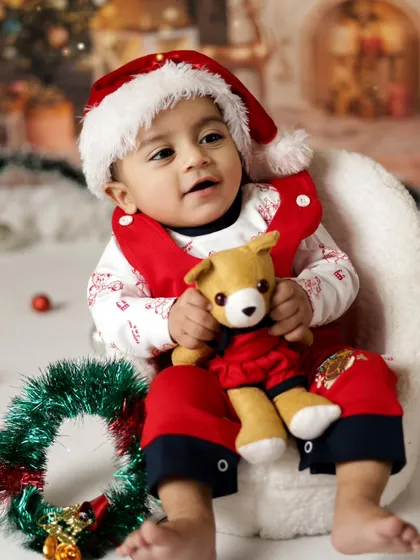 Holding his little teddy bear, this baby is all ready for Christmas. Our studio is filled with props to make the session fun and engaging.