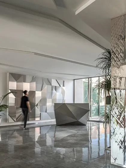 The reception space was designed with clean lines and a minimalist aesthetic, using reflective surfaces and integrated lighting to create a sense of spaciousness.