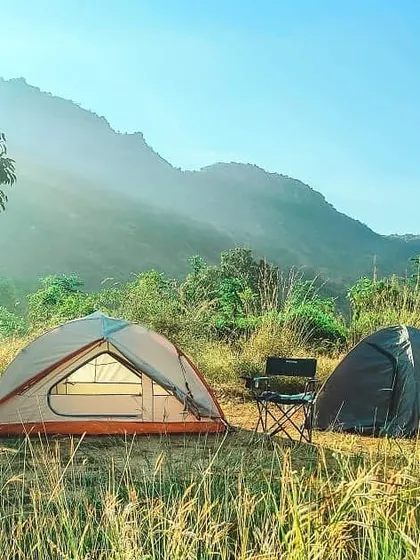 A simple, sun-drenched campsite in the foothills. This setup is perfect for a relaxed weekend, soaking in the morning sun and breathing in the fresh air with a beautiful mountain range in the background.