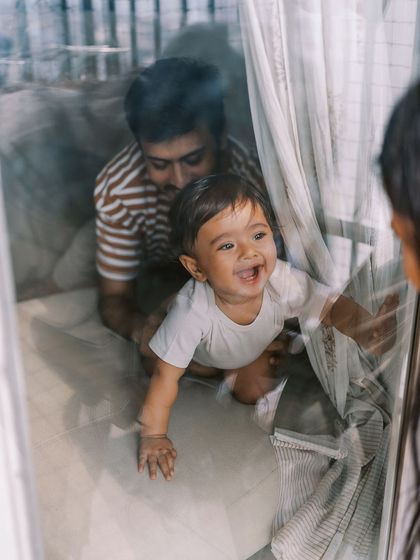 A baby playing peek-a-boo through a window. These spontaneous moments of play are often the best.