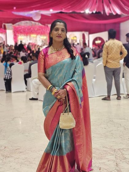 Vijetha at a wedding reception, her saree looking elegant and sophisticated in the grand setting.