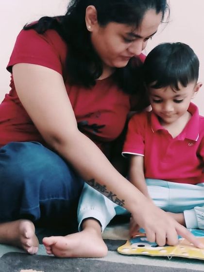 A quiet moment of connection as a mother and child read a book together. We foster these bonds by creating a welcoming environment for families.