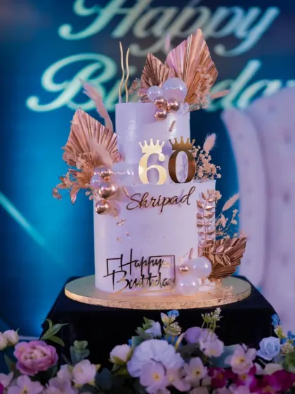 A classic white and gold two-tier cake for a 60th birthday celebration. This elegant design features custom toppers and delicate gold leaf accents, perfect for marking a major milestone with style. The flavour inside was my classic Swiss Chocolate.