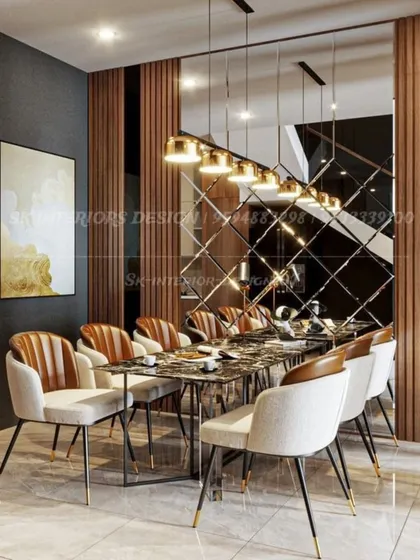 A modern dining area defined by a wood-paneled wall and a striking geometric mirror. The combination of textures and reflective surfaces adds a layer of warmth and contemporary style.