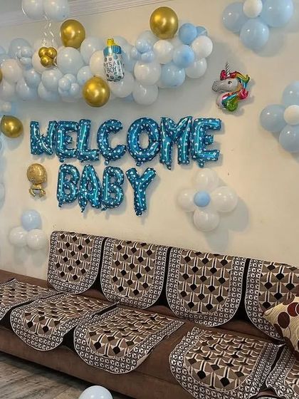 An alternate angle of the blue and gold "Welcome Baby" wall decor, showing how it fits neatly above a sofa.