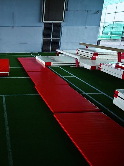 The bright red mats of our gymnastics area, laid out and ready for tumbles, flips, and floor exercises.