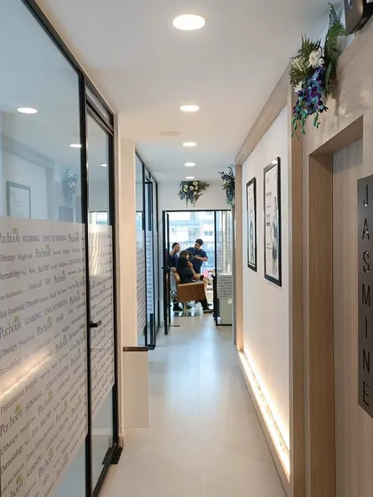 This is a view down the corridor of our new Vasundhara clinic, leading to our private treatment rooms like 'Jasmine'. The space is designed to be serene and clean, ensuring a peaceful and professional environment for all your aesthetic and wellness treatments.