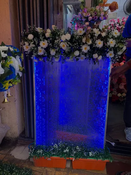 The waterfall decor piece illuminated with a deep blue light. You can choose the color to match your overall theme, making it a versatile and captivating addition to your mandap.