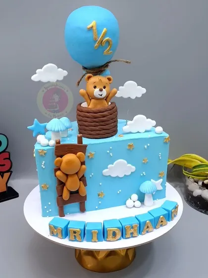 A detailed teddy bear themed half-birthday cake, complete with a hot air balloon and ladder.