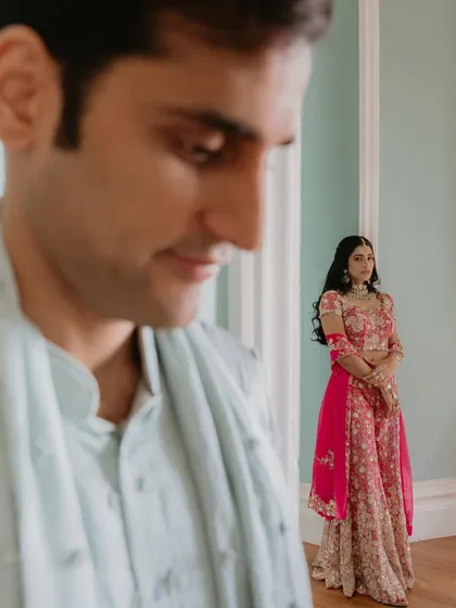 A creative composition focusing on the bride, with the groom in the foreground. This adds depth and a narrative quality to the portrait, suggesting a story of love and anticipation.
