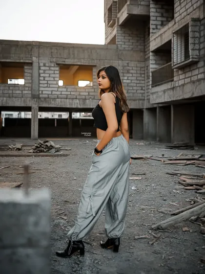 A full-length shot showcasing the model's street style outfit against the backdrop of the construction site, turning the urban landscape into a runway.